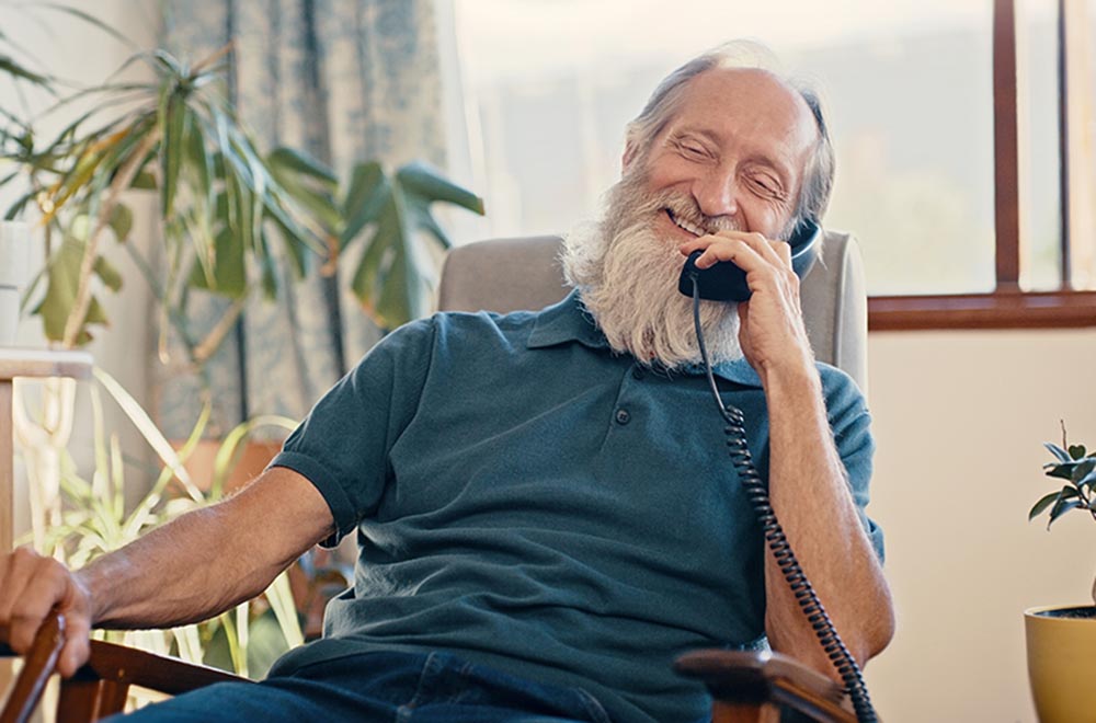 Senior man with a beard on a landline phone call